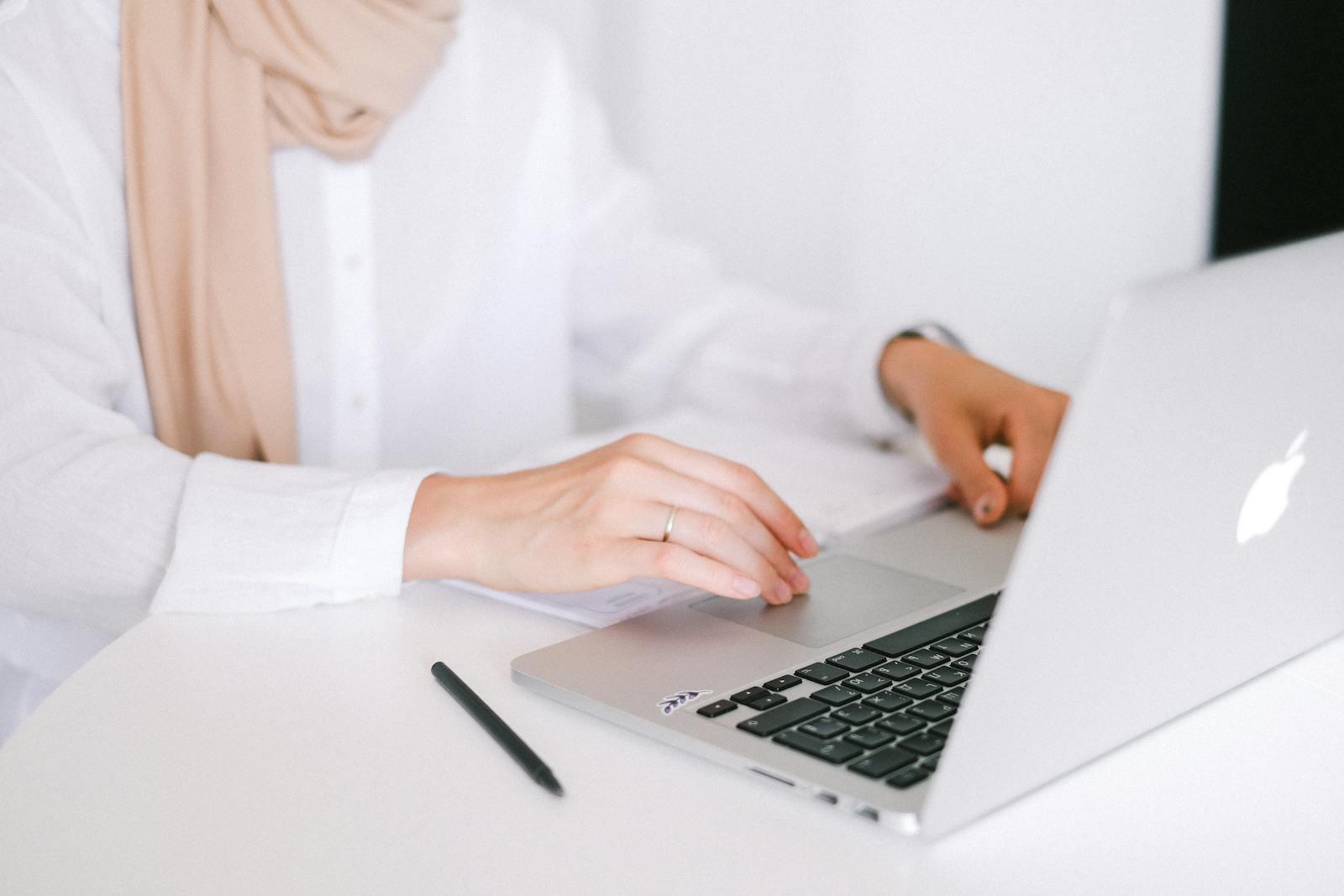 Close-up of a person working on a laptop in a modern home office setting.